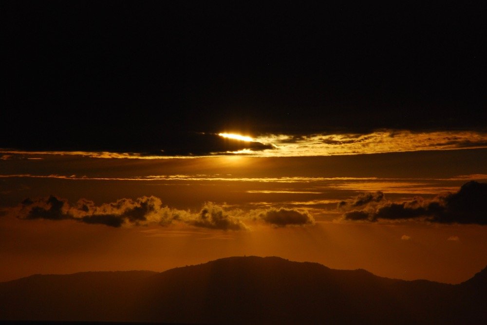 Zonsondergang in Salerno met imposante wolkenlucht en warme gele gloed.