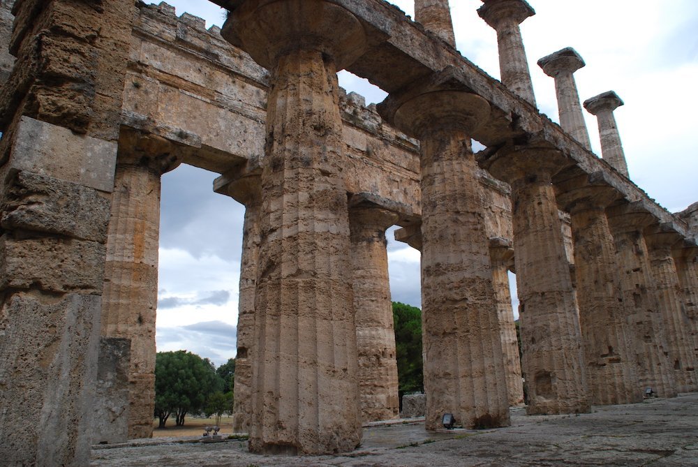 Doorkijkje door de ruïnes van een van de oude Griekse tempels in Paestum, Italië