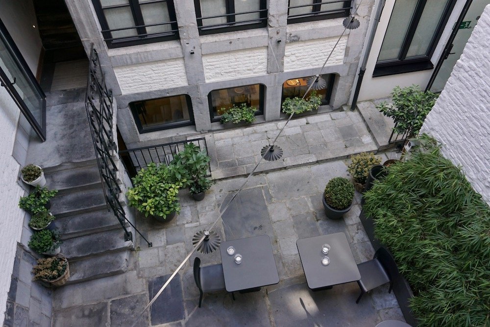 Binnenplaats van Hotel Neuvice in Luik met sfeervolle zitjes en groen