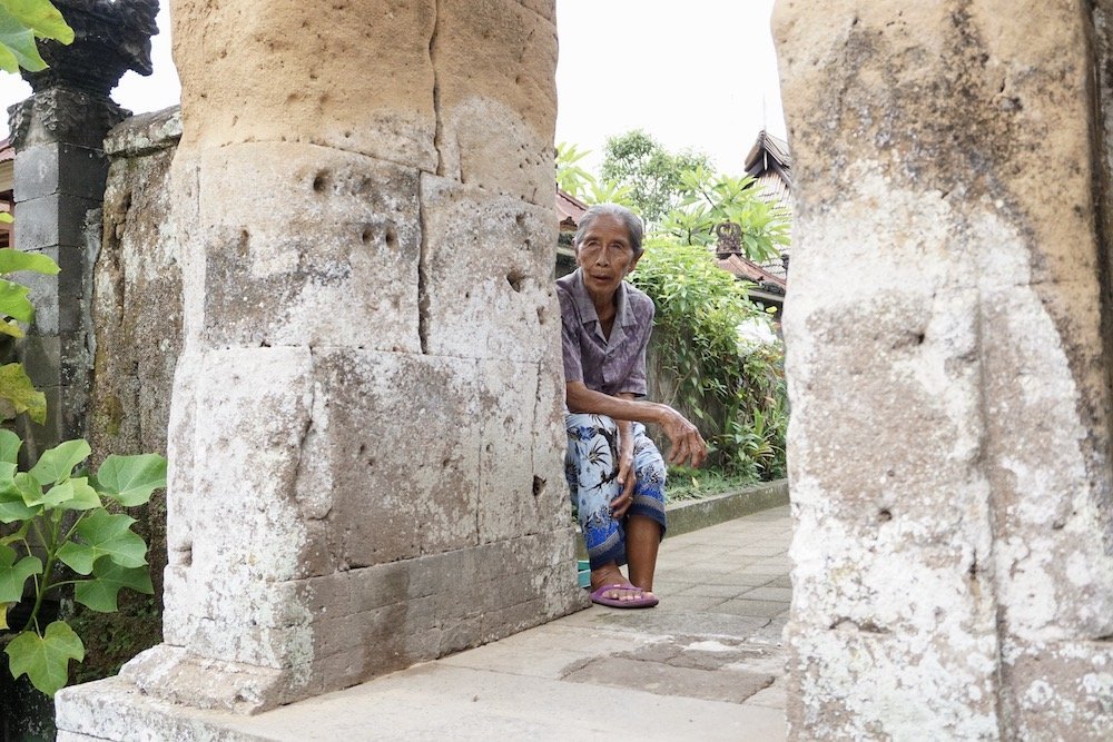 Vrouw zit bij haar huis in Penglipuran Village
